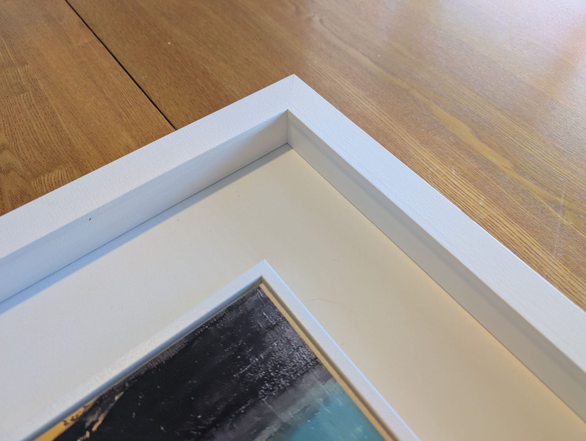 Close-up of the tray frame's crisp mitre joint and wood texture